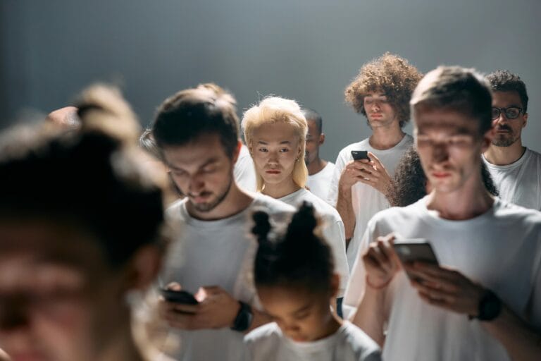 Juiz Aprova Proibição de Feeds Viciantes para Menores na Califórnia 5 A diverse group of people looking at smartphones, illustrating social isolation in modern technology.